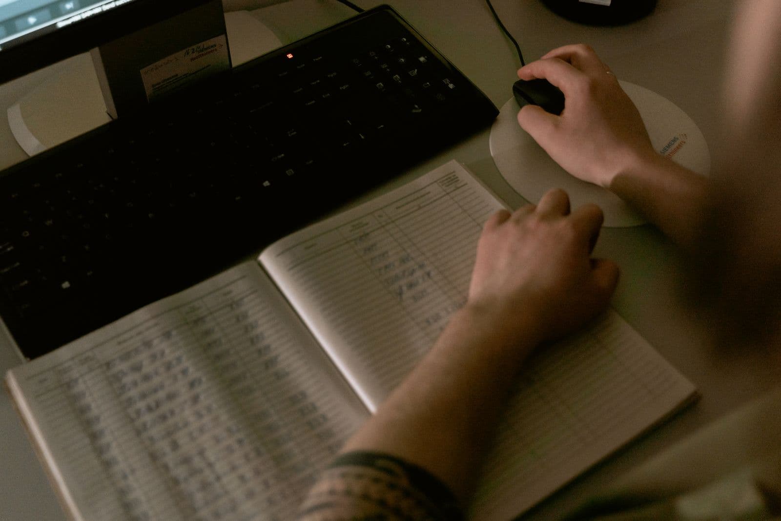 Healthcare professional reviewing payment and administrative records at a computer