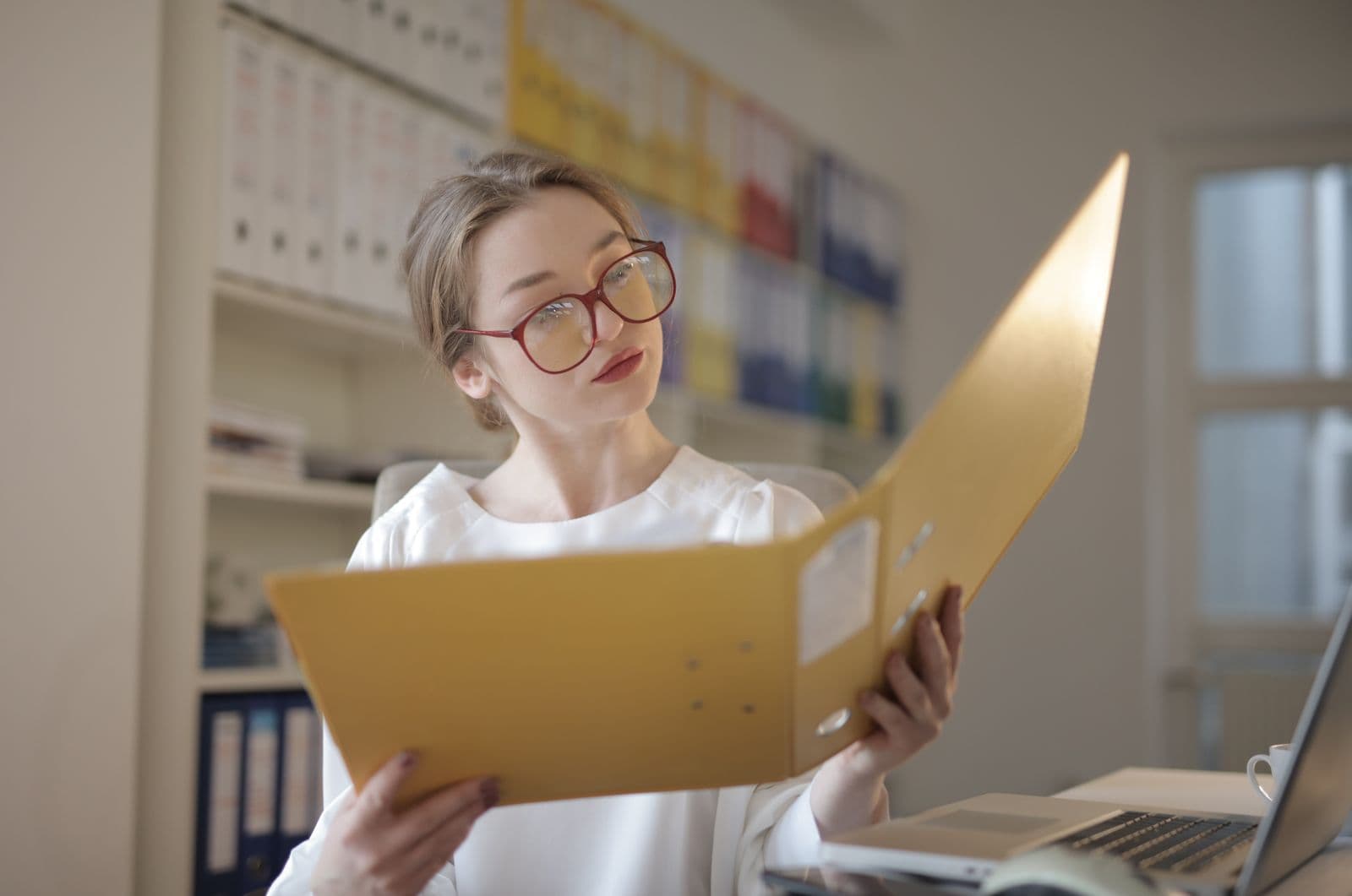 Business professional reviewing payroll and tax records at an office desk